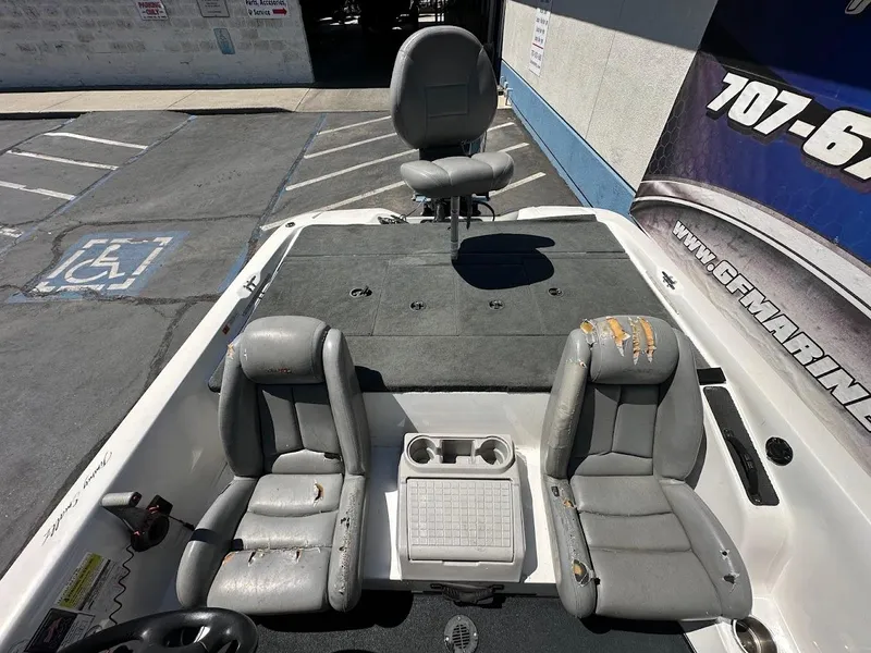 Slide: The Image of 2004 Stratos 285 PRO XL DC boat interior with worn gray seats and fishing deck. - 14