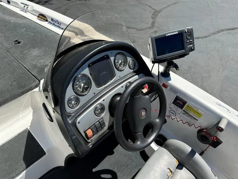 Slide: The Image of 2004 Stratos 285 PRO XL DC boat dashboard with steering wheel and Lowrance fishfinder. - 16