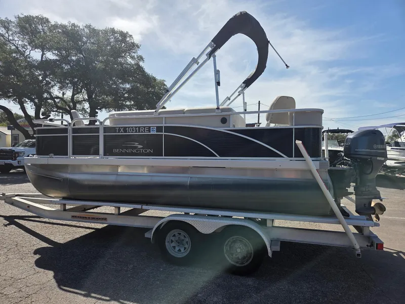 Slide: The Image of 2019 Bennington SV 188 SFV 8' Narrow Beam pontoon boat on trailer, parked outdoors. - 11