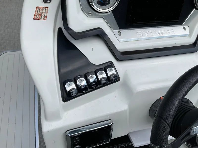Slide: The Image of Control panel of a 2019 Sylvan SE-CRS25 boat with switches and steering wheel. - 27