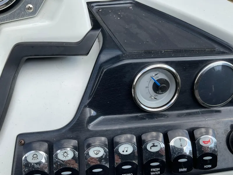 Slide: The Image of Control panel of a 2019 Sylvan SE-CRS25 boat with various switches and a gauge. - 29