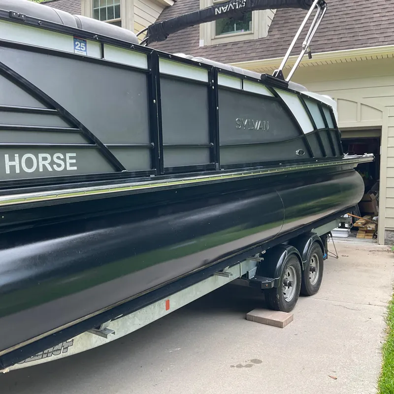 Slide: The Image of 2019 Sylvan SE-CRS25 pontoon boat on trailer, parked near a house. - 3