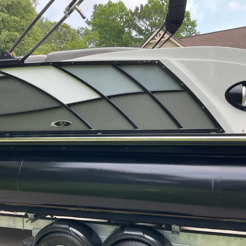 Slide: The Image of 2019 Sylvan SE-CRS25 pontoon boat side view with sleek design and trailer. - 5