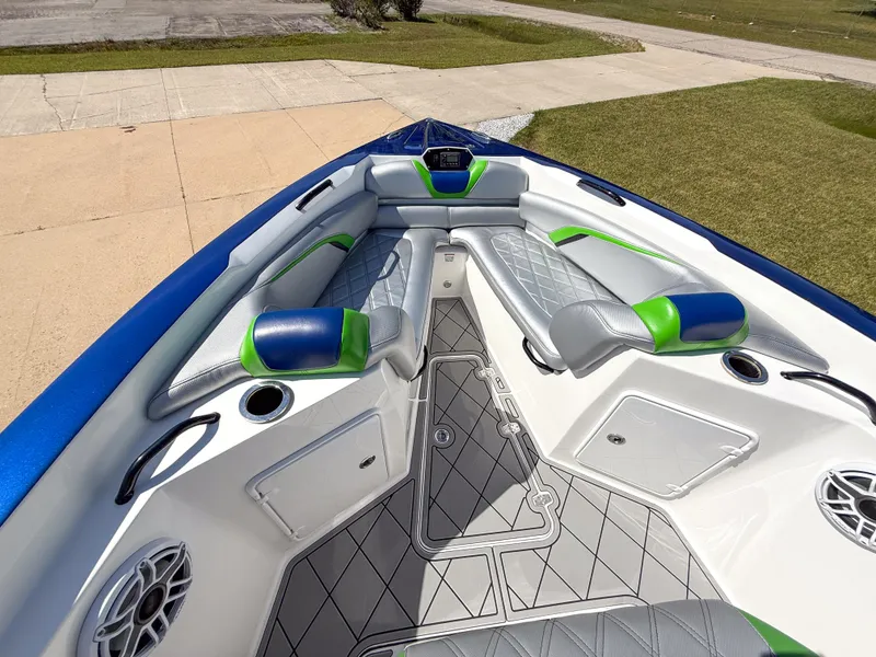 Slide: The Image of 2018 Sunsation 32 CCX boat interior with blue and green accents, featuring cushioned seating. - 12