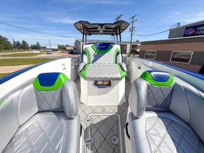 Slide: The Image of 2018 Sunsation 32 CCX boat interior with modern seating and vibrant green accents. - 13