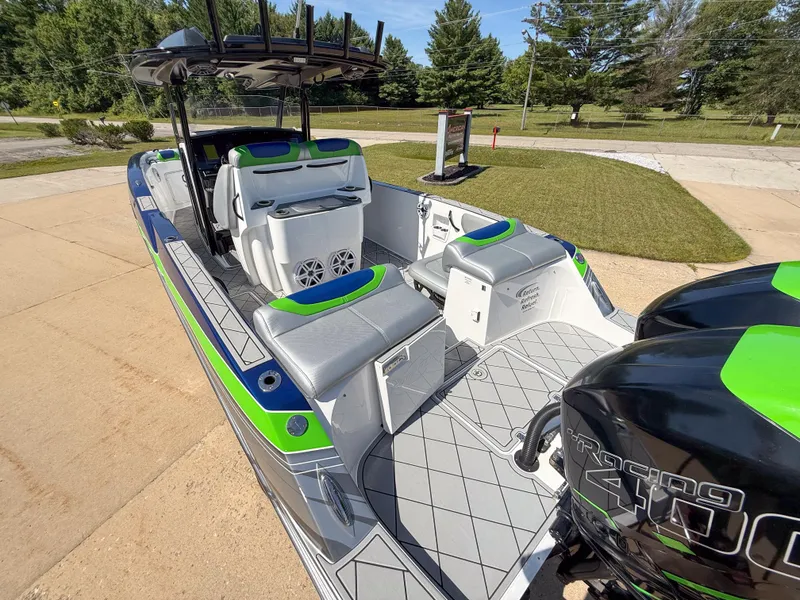 Slide: The Image of 2018 Sunsation 32 CCX boat with vibrant green and gray seating, docked outdoors. - 2