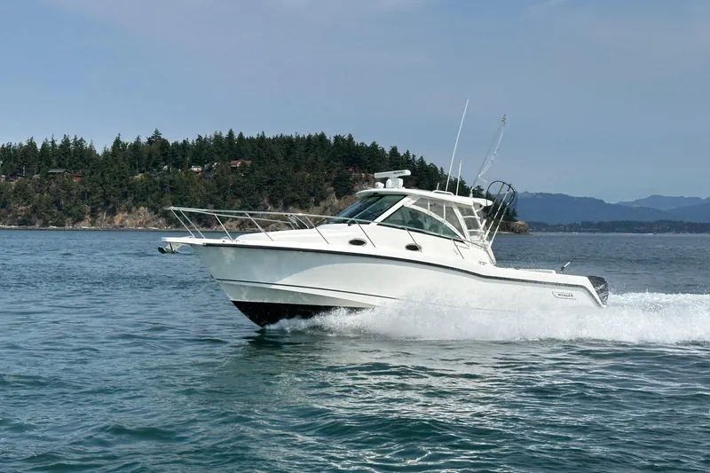 Slide: The Image of 2013 Boston Whaler 345 Conquest cruising on a scenic lake with forested shoreline. - 0