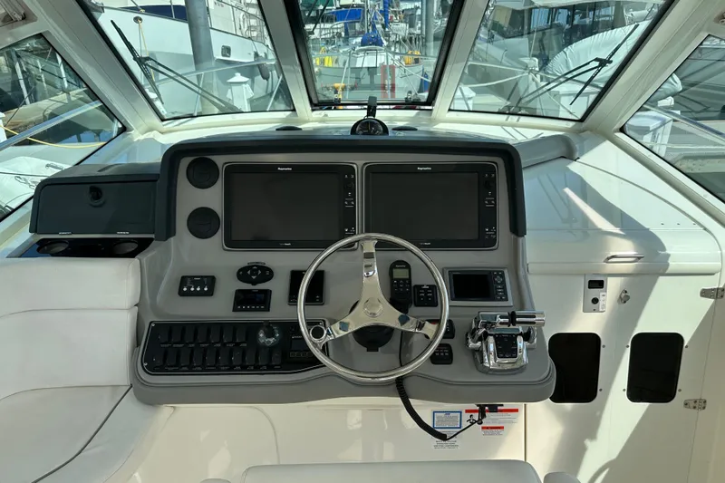 Slide: The Image of 2013 Boston Whaler 345 Conquest helm with dual screens and steering wheel. - 12