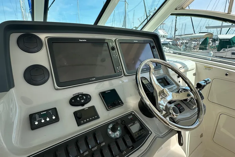 Slide: The Image of 2013 Boston Whaler 345 Conquest helm with modern navigation equipment and steering wheel. - 16