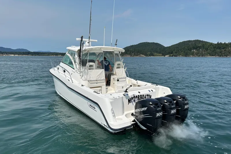 Slide: The Image of 2013 Boston Whaler 345 Conquest boat with triple Mercury engines on open water. - 2