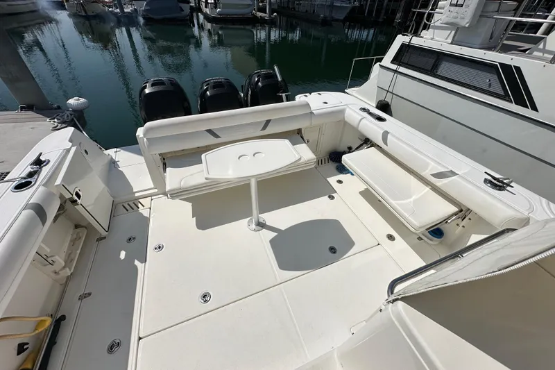 Slide: The Image of 2013 Boston Whaler 345 Conquest boat deck with seating and table, docked at marina. - 23