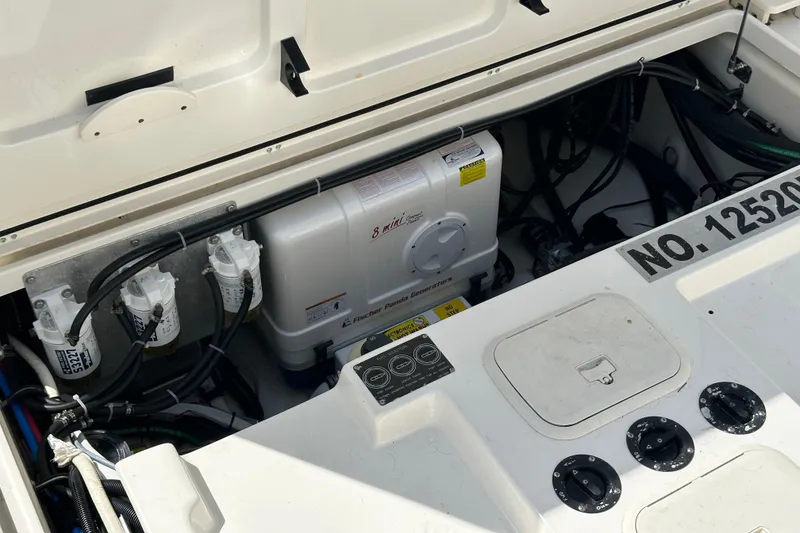 Slide: The Image of Engine compartment of a 2013 Boston Whaler 345 Conquest with visible generator and wiring. - 25