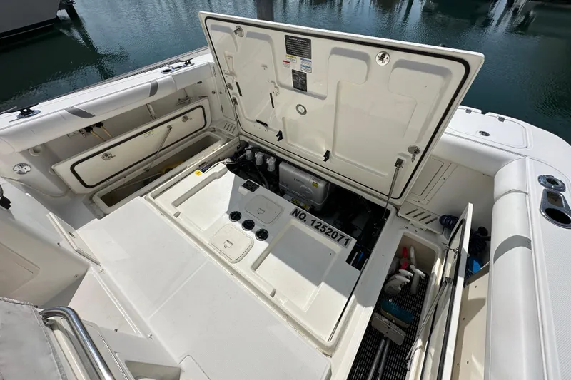 Slide: The Image of 2013 Boston Whaler 345 Conquest boat with open storage compartments and engine access. - 26