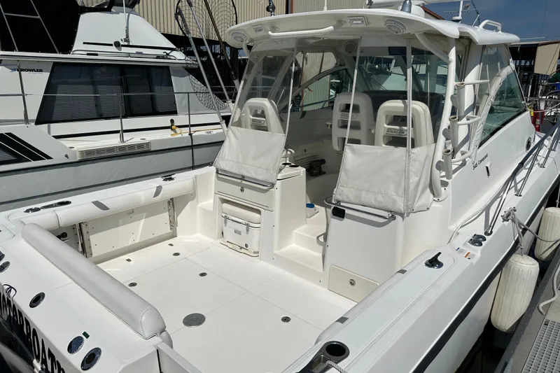 Slide: The Image of 2013 Boston Whaler 345 Conquest boat docked, showcasing spacious cockpit and seating area. - 27