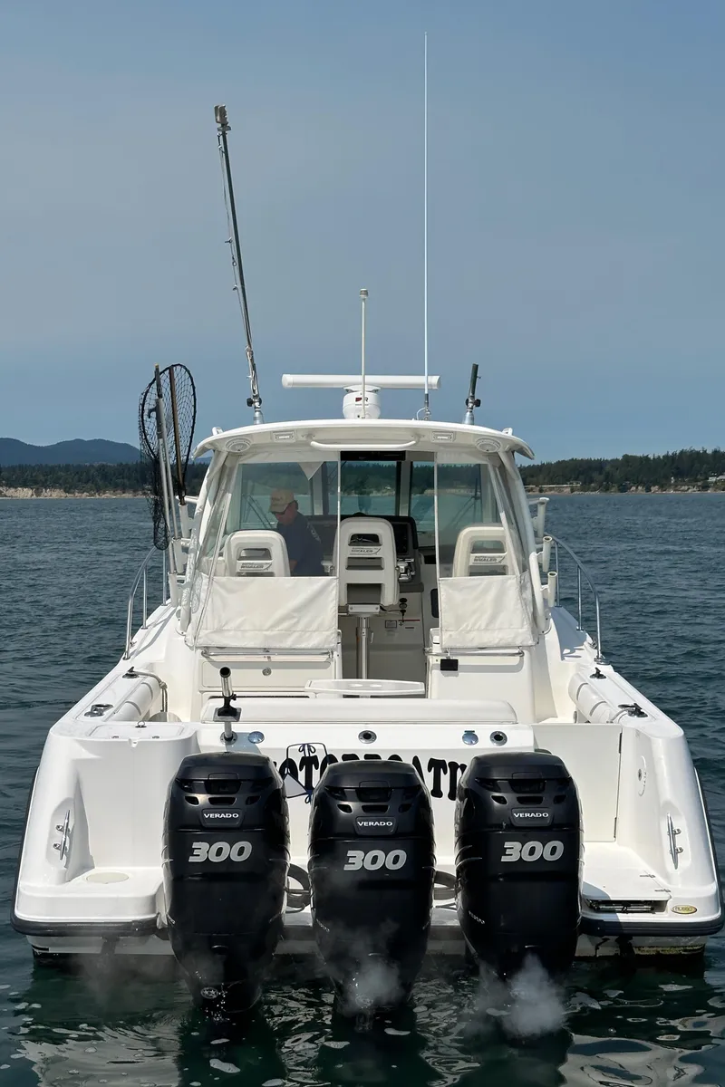 Slide: The Image of 2013 Boston Whaler 345 Conquest boat with triple 300 horsepower engines on open water. - 3