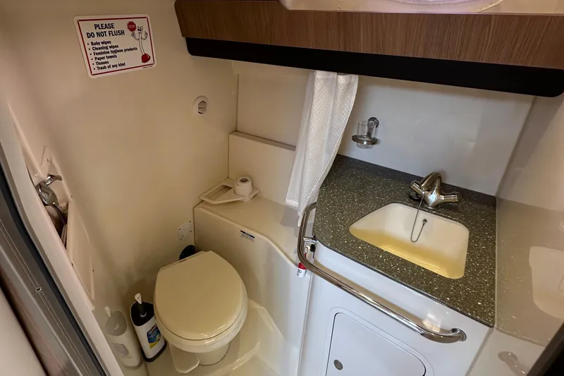 Slide: The Image of 2013 Boston Whaler 345 Conquest bathroom with toilet, sink, and storage. - 34