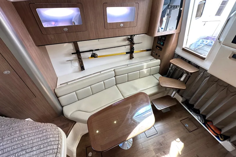 Slide: The Image of Interior of 2013 Boston Whaler 345 Conquest with seating, table, and fishing rod storage. - 36