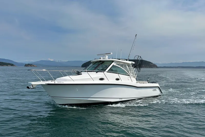 Slide: The Image of 2013 Boston Whaler 345 Conquest cruising on open water, scenic background. - 7