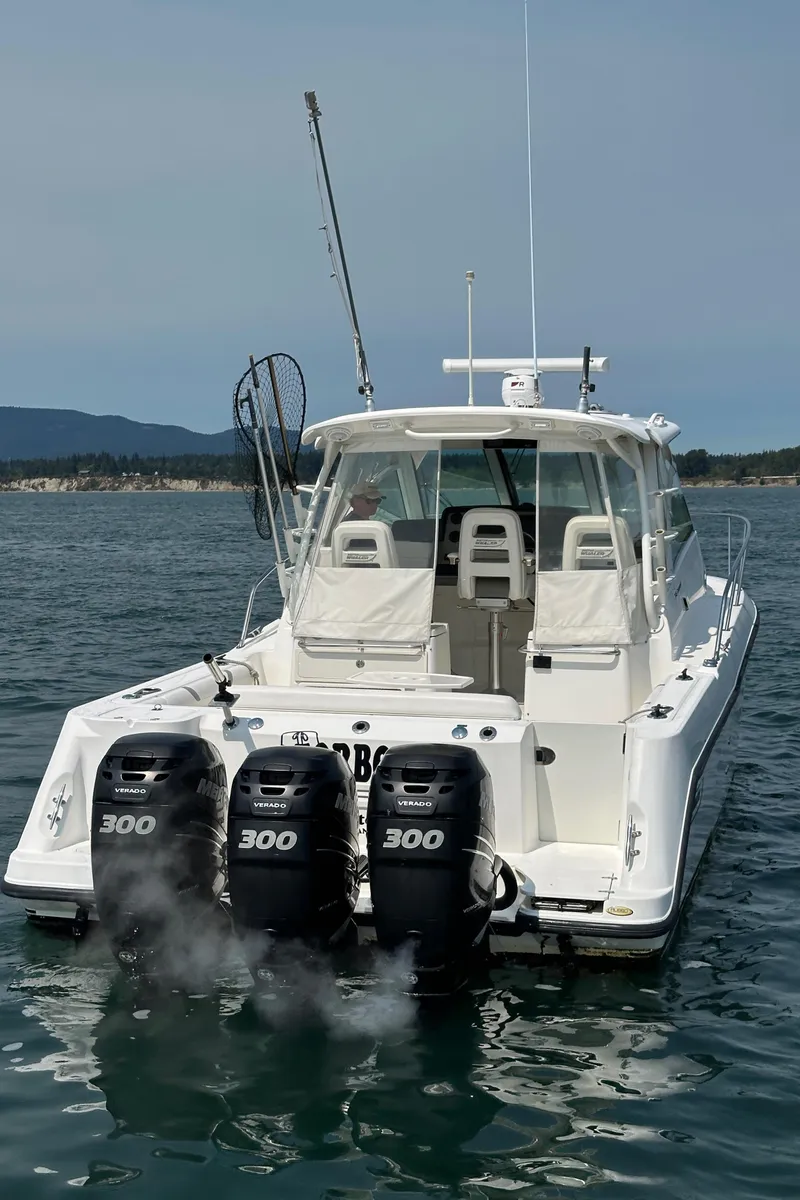 Slide: The Image of 2013 Boston Whaler 345 Conquest boat with triple 300 horsepower engines on open water. - 9