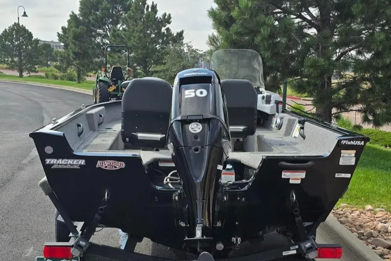 Slide: The Image of 2019 Tracker PGV16 boat with 50HP engine, parked near trees. - 5