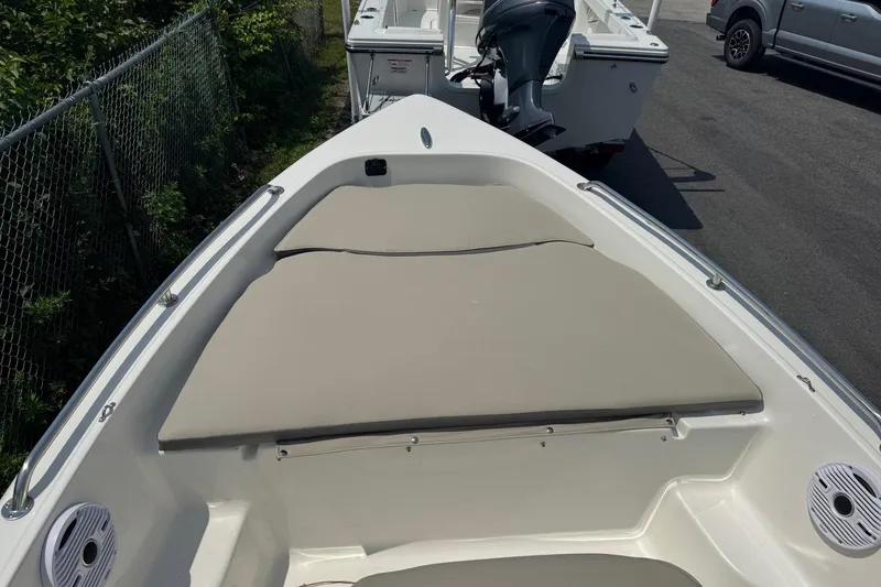 Slide: The Image of 2026 Key West 1720 CC boat with cushioned bow seating, parked outdoors. - 5