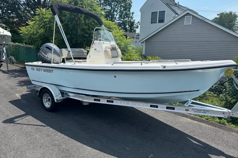 Slide: The Image of 2026 Key West 1720 CC boat on trailer, parked outdoors near a house. - 7