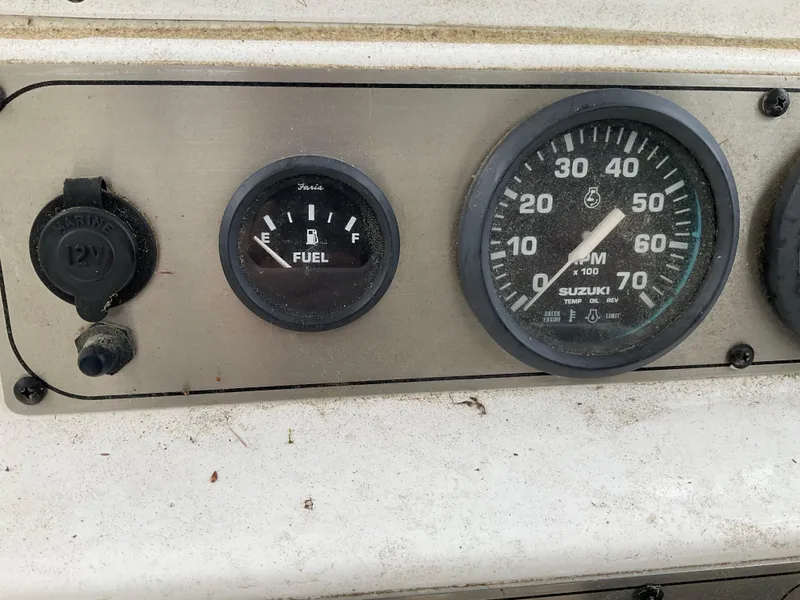 Slide: The Image of Dashboard of a 2009 Key West 2300WA boat with fuel and RPM gauges. - 13