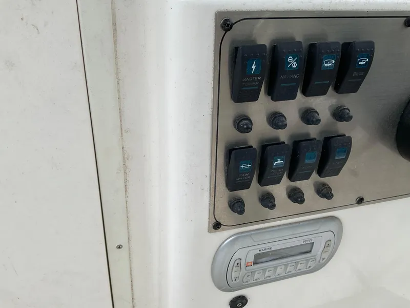 Slide: The Image of Control panel of a 2009 Key West 2300WA boat with switches and marine radio. - 14