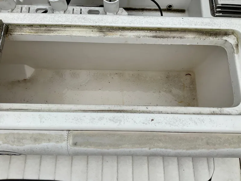 Slide: The Image of Open storage compartment on a 2009 Key West 2300WA boat, showing wear and dirt. - 16