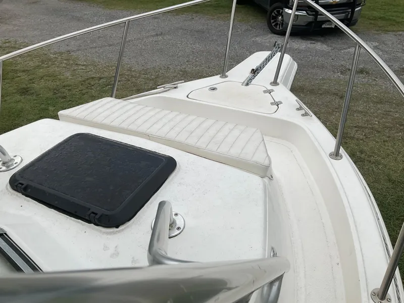 Slide: The Image of 2009 Key West 2300WA boat deck with railing and hatch, parked on grass. - 18