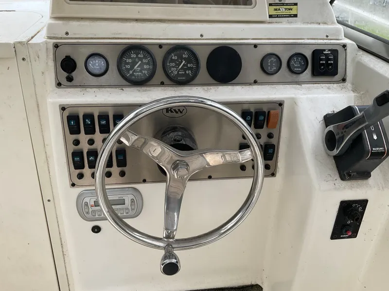 Slide: The Image of Dashboard of a 2009 Key West 2300WA boat with steering wheel and controls. - 31