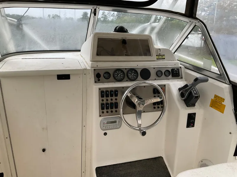 Slide: The Image of 2009 Key West 2300WA boat dashboard with steering wheel and control panel. - 33