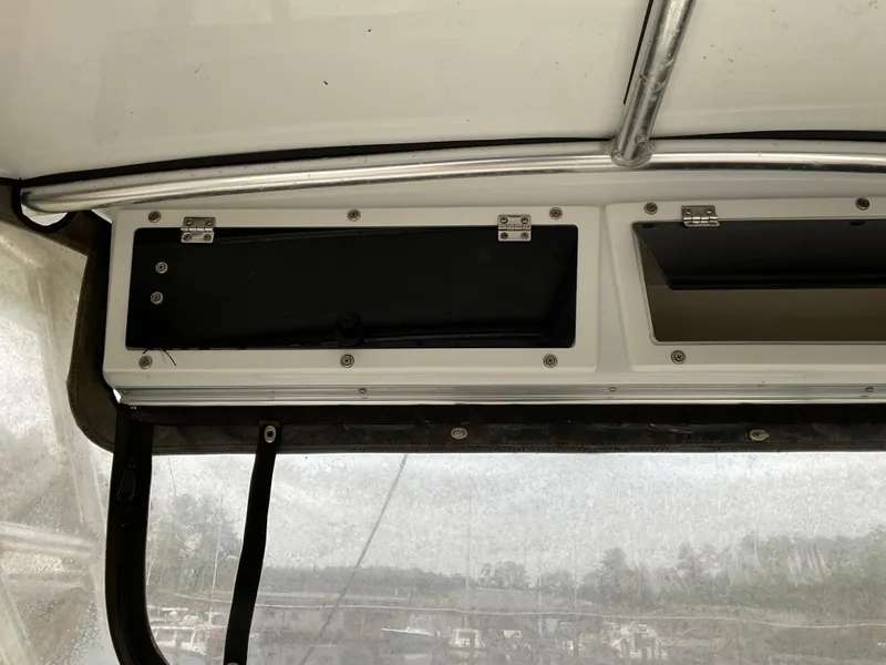 Slide: The Image of 2009 Key West 2300WA boat interior storage compartments with metal hinges. - 7