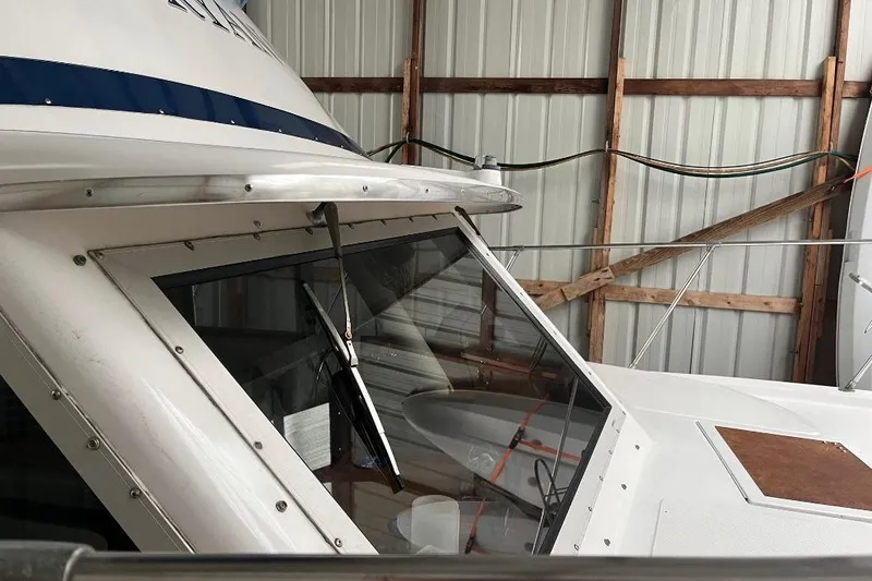 Slide: The Image of 1976 Uniflite 32 Sport Sedan boat in storage, showcasing cabin window and wiper. - 10