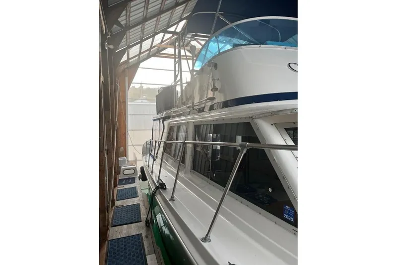 Slide: The Image of 1976 Uniflite 32 Sport Sedan docked in a covered marina, side view. - 12