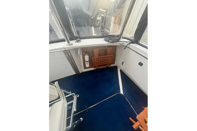 Slide: The Image of 1976 Uniflite 32 Sport Sedan interior with blue carpet and seating area. - 20