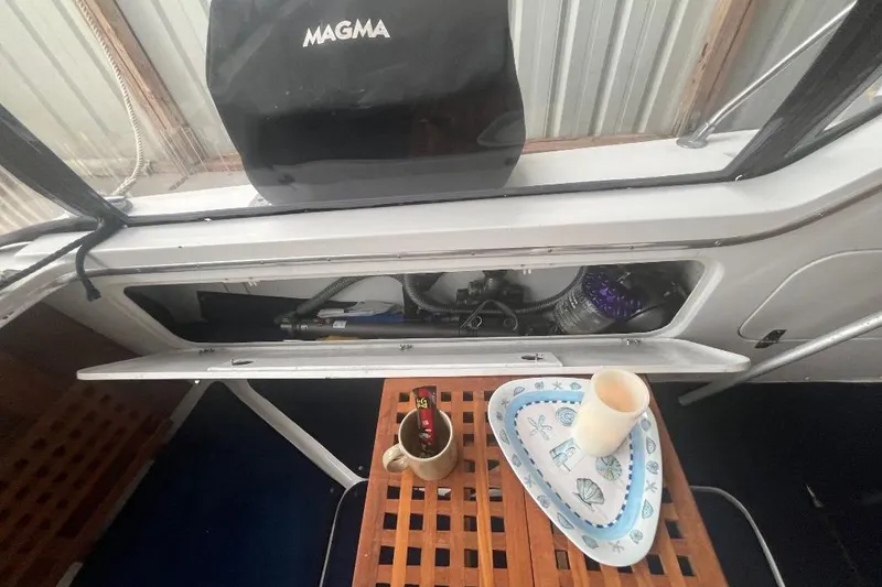 Slide: The Image of 1976 Uniflite 32 Sport Sedan interior with open storage, tray, and cups. - 21