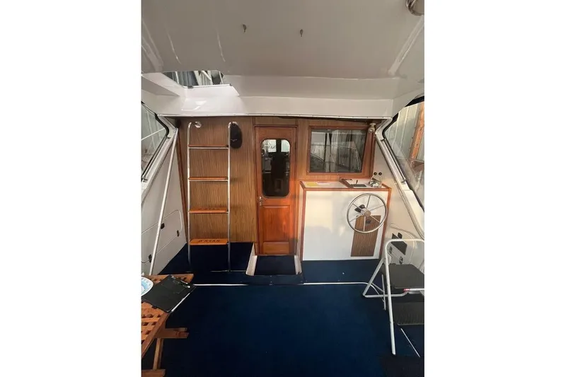 Slide: The Image of 1976 Uniflite 32 Sport Sedan interior with wooden accents and steering wheel. - 25