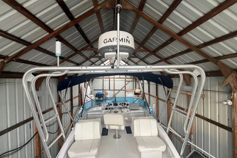Slide: The Image of 1976 Uniflite 32 Sport Sedan boat in a metal-roofed storage, featuring Garmin equipment. - 27
