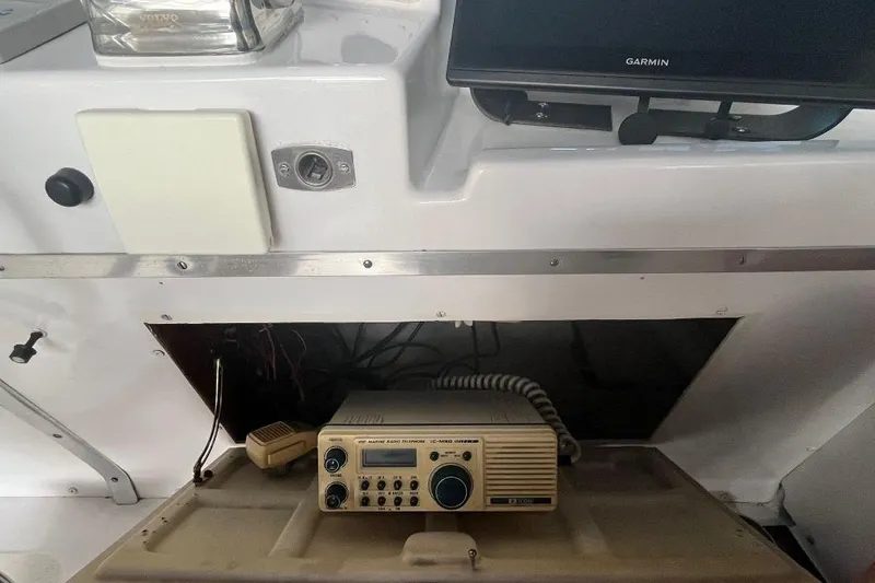 Slide: The Image of 1976 Uniflite 32 Sport Sedan dashboard with marine radio and Garmin display. - 32