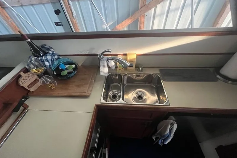 Slide: The Image of 1976 Uniflite 32 Sport Sedan kitchen with sink, cutting board, and wine bottle. - 43