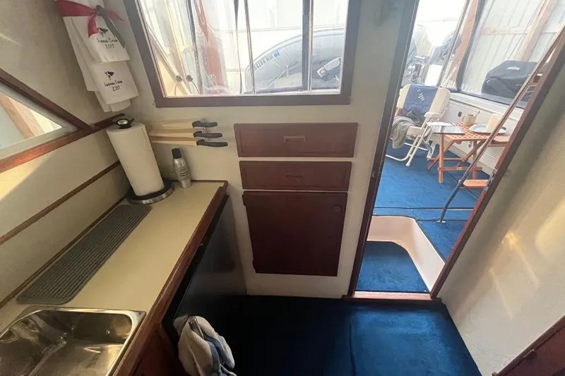 Slide: The Image of 1976 Uniflite 32 Sport Sedan interior with kitchenette and blue carpeted floor. - 45