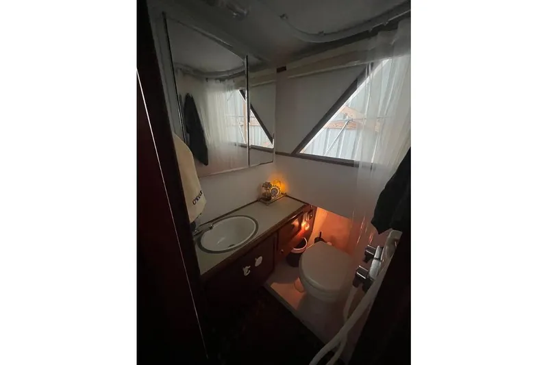 Slide: The Image of 1976 Uniflite 32 Sport Sedan bathroom with sink, toilet, and mirror. - 48
