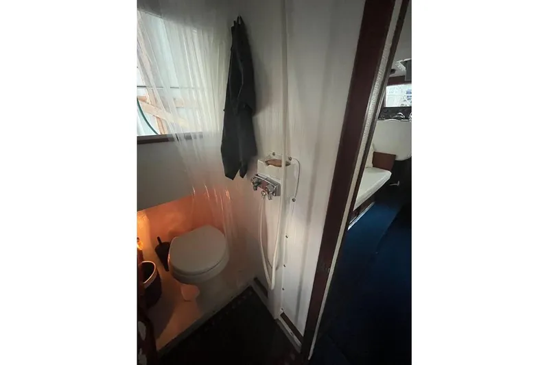 Slide: The Image of 1976 Uniflite 32 Sport Sedan bathroom with toilet and shower area. - 49