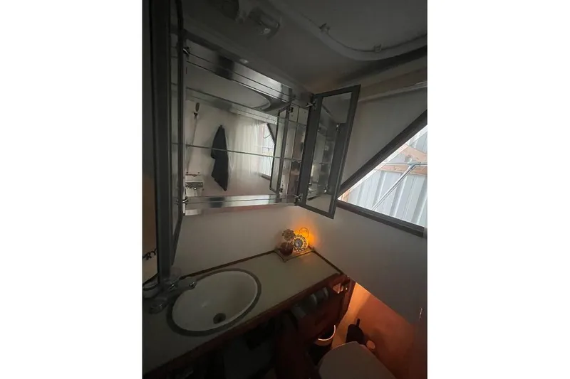 Slide: The Image of 1976 Uniflite 32 Sport Sedan bathroom with sink, mirror, and window. - 51