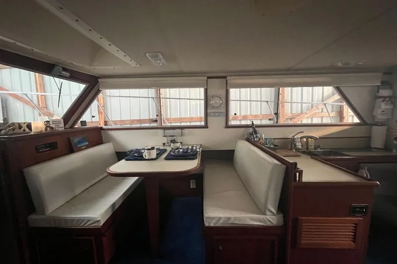 Slide: The Image of 1976 Uniflite 32 Sport Sedan interior with dining area and kitchenette. - 53