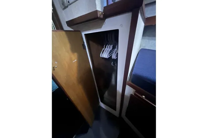 Slide: The Image of 1976 Uniflite 32 Sport Sedan interior closet with hangers and wooden door. - 61