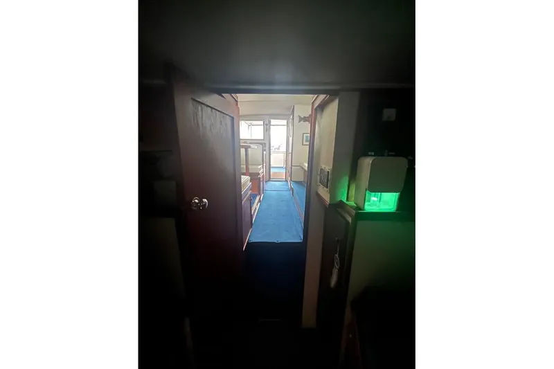 Slide: The Image of Interior view of 1976 Uniflite 32 Sport Sedan with blue carpet and wooden door. - 65