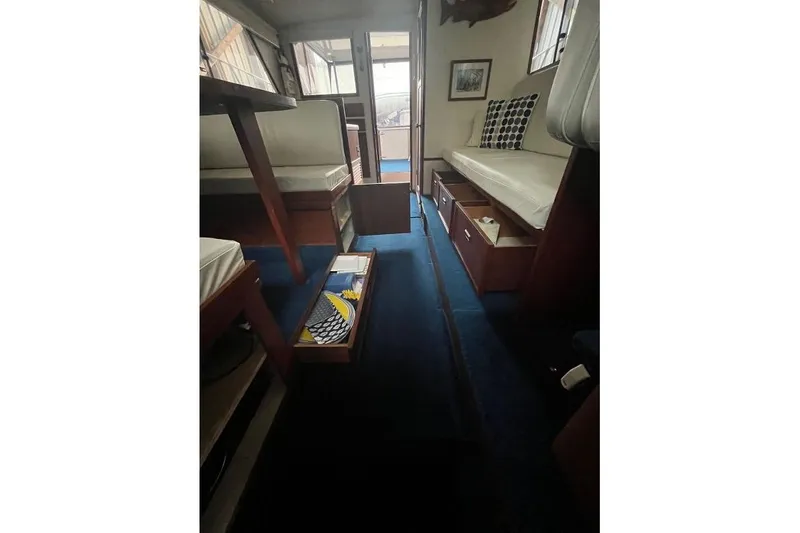 Slide: The Image of 1976 Uniflite 32 Sport Sedan interior with seating, table, and blue carpet. - 66