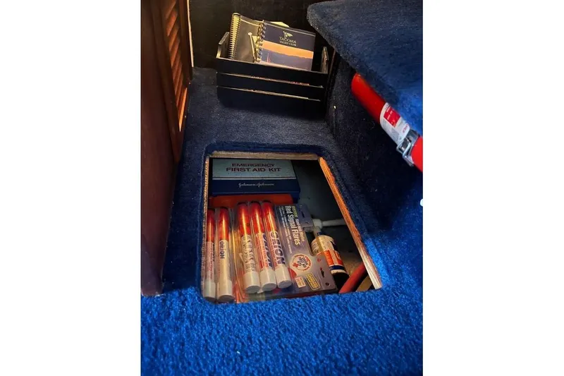 Slide: The Image of 1976 Uniflite 32 Sport Sedan interior storage with first aid kit and emergency supplies. - 80